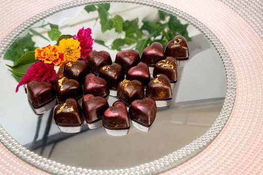 Heart-shaped chocolates with flowers on a mirrored tray, end Love Month with a date night that actually means something.