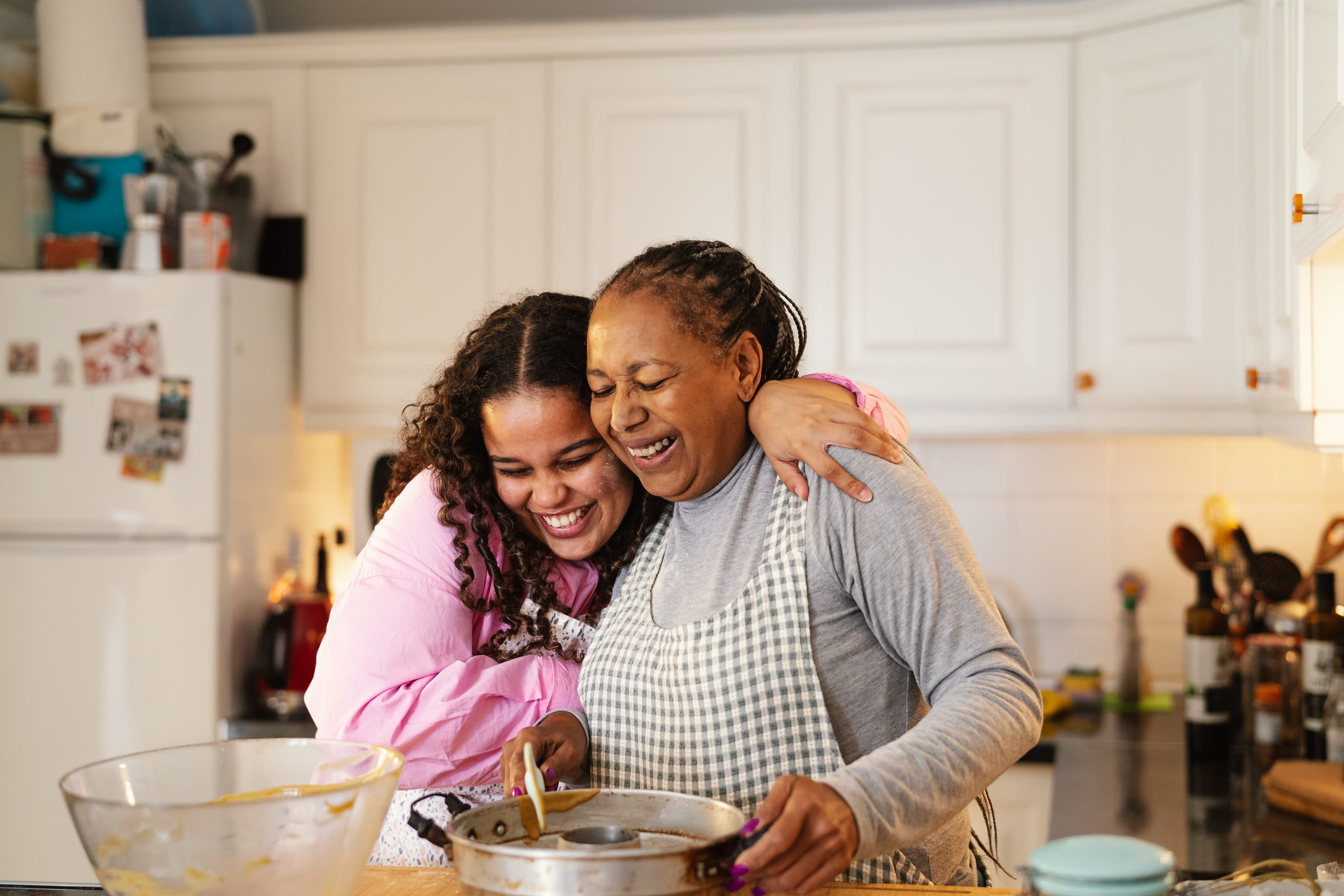 Gift for Culinary-Obsessed Mums, buy a cookbook online while a mother and daughter cook happily together. 