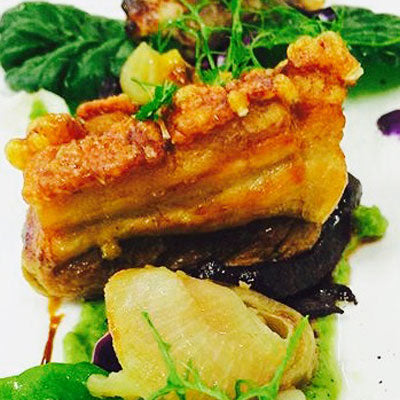 Beautiful sun-tanned beer-braised pork belly with caramelised apples